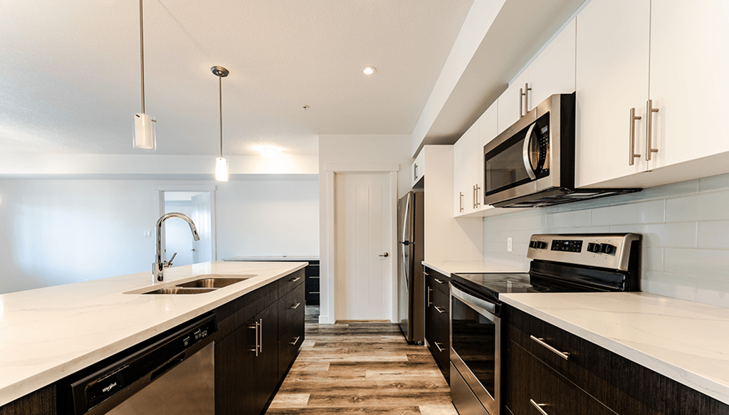 A modern kitchen with black cabinets and white countertops.