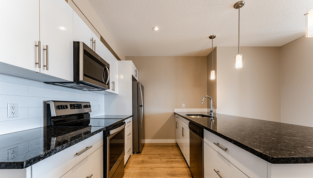 A kitchen with black countertops and white cabinets.