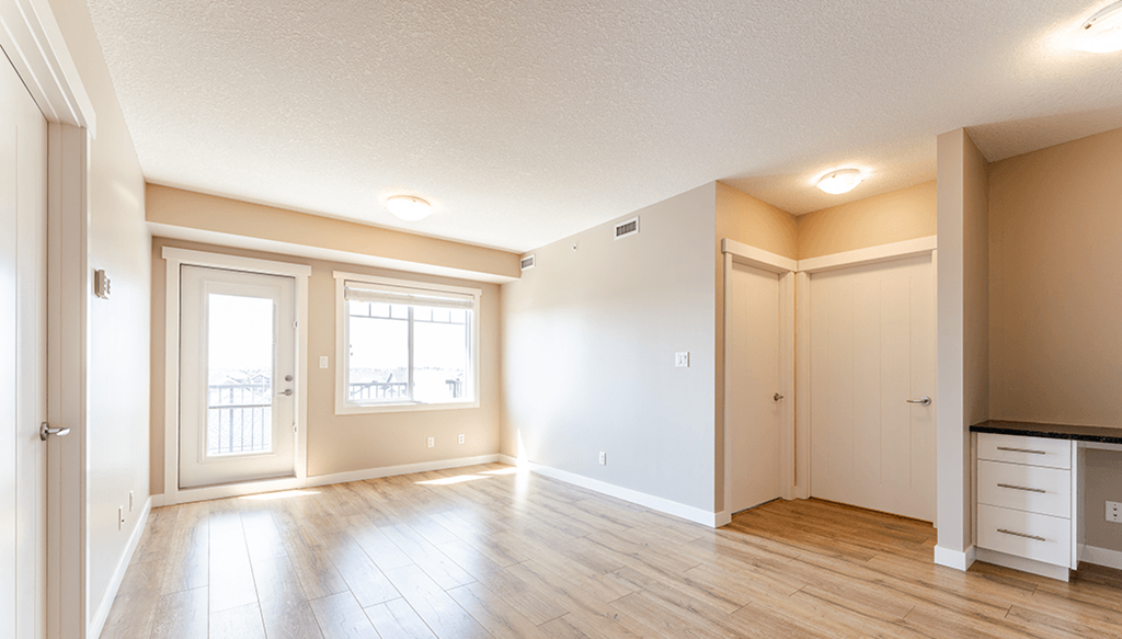 A spacious room with wooden floors and white walls.
