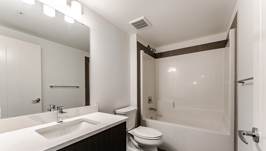 A white bathroom with a sink, toilet, and bathtub.