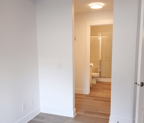 A white bathroom with a glass shower door.