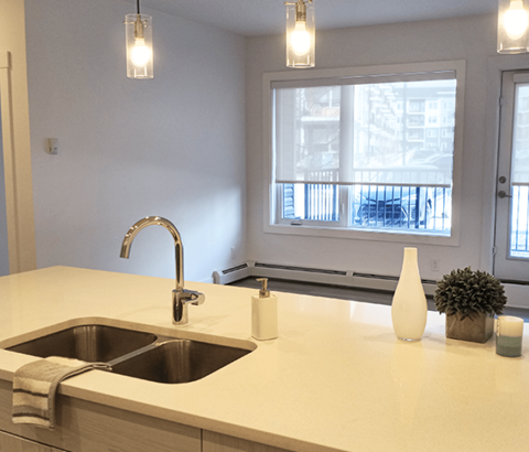 A kitchen counter with a sink and a window in the background.