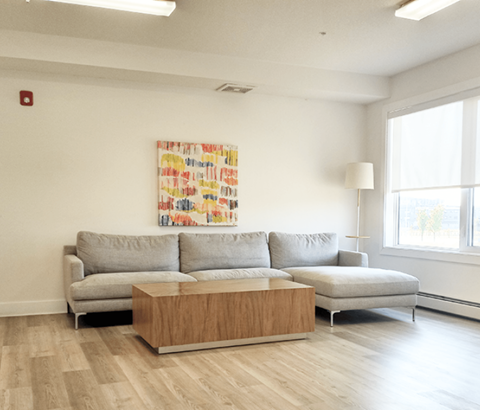 A living room with a grey couch and a wooden coffee table.