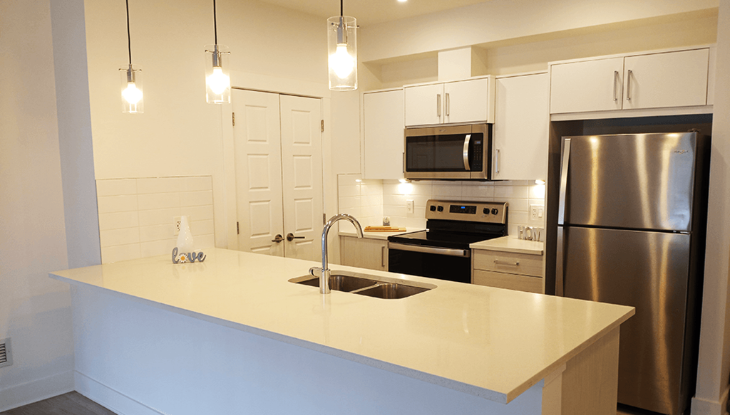 a kitchen with stainless steel appliances and a white counter top