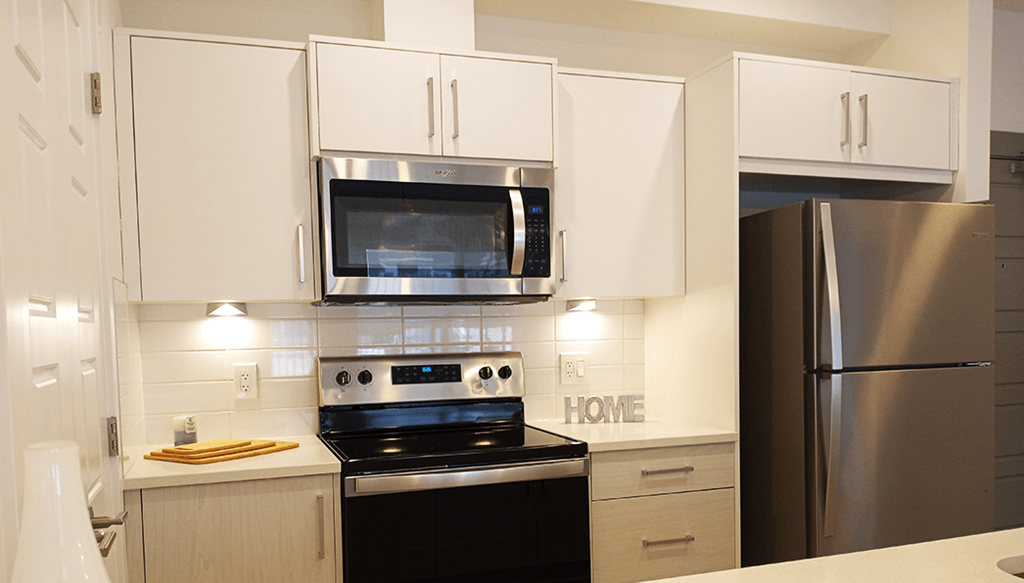 a kitchen with white cabinets and a stove and a microwave