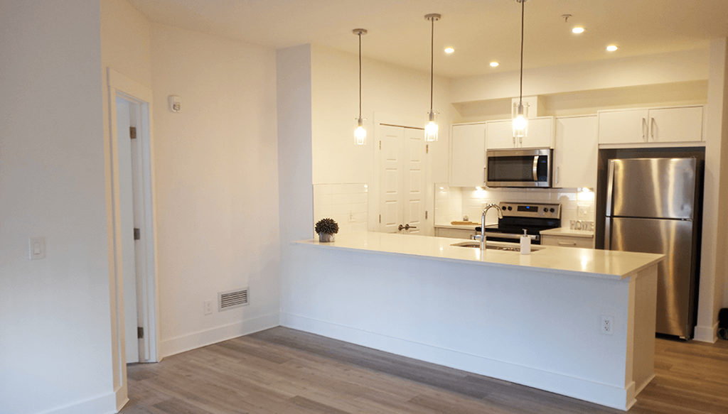 a kitchen with a large island and a stainless steel refrigerator