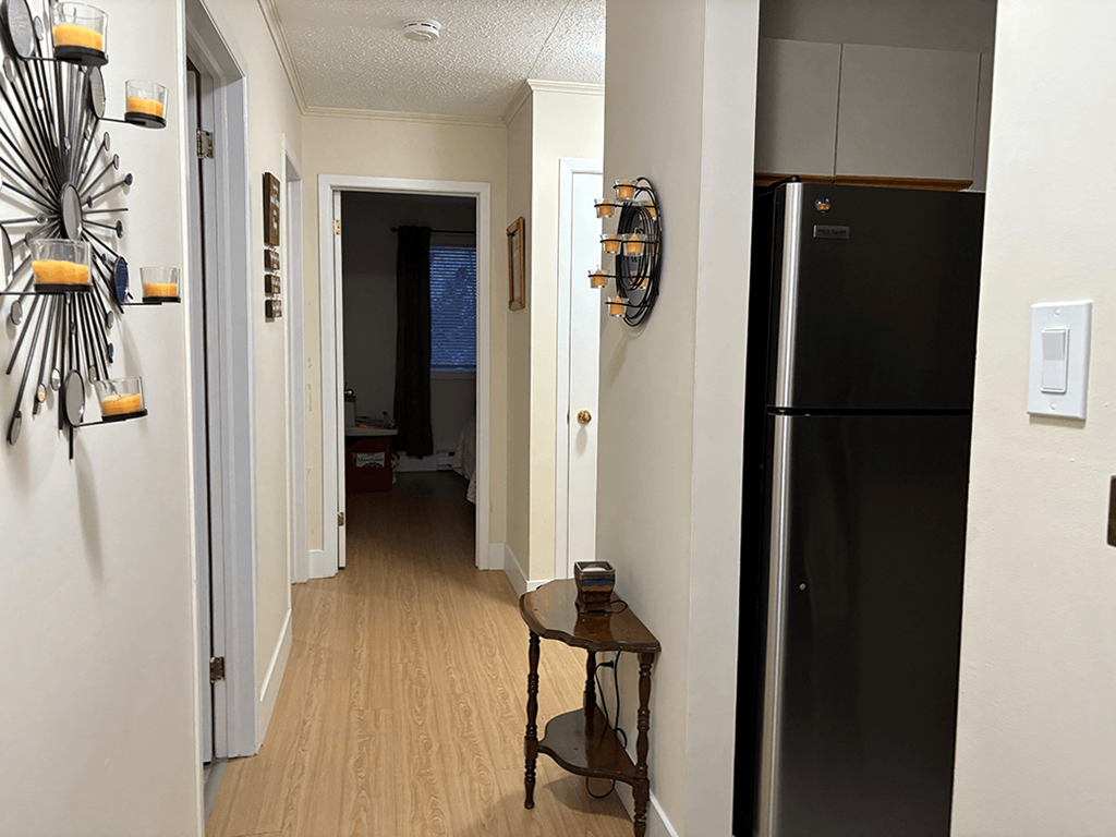 A black refrigerator is in a kitchen with a table and chairs.
