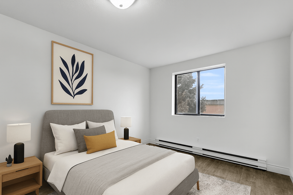 A bedroom with a large bed and a framed picture on the wall.