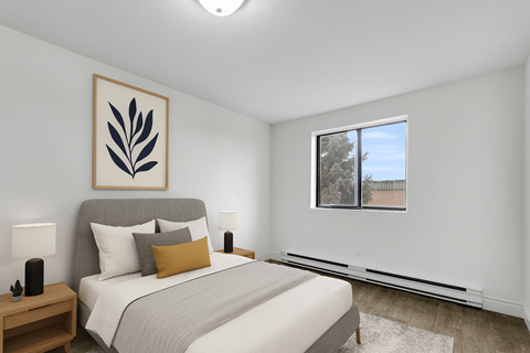 A bedroom with a large bed and a framed picture on the wall.