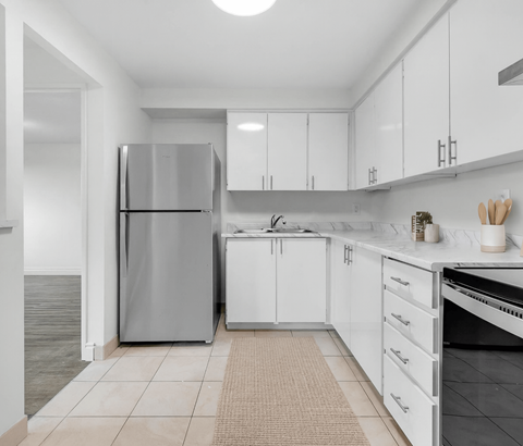 A modern kitchen with white cabinets and a stainless steel refrigerator.