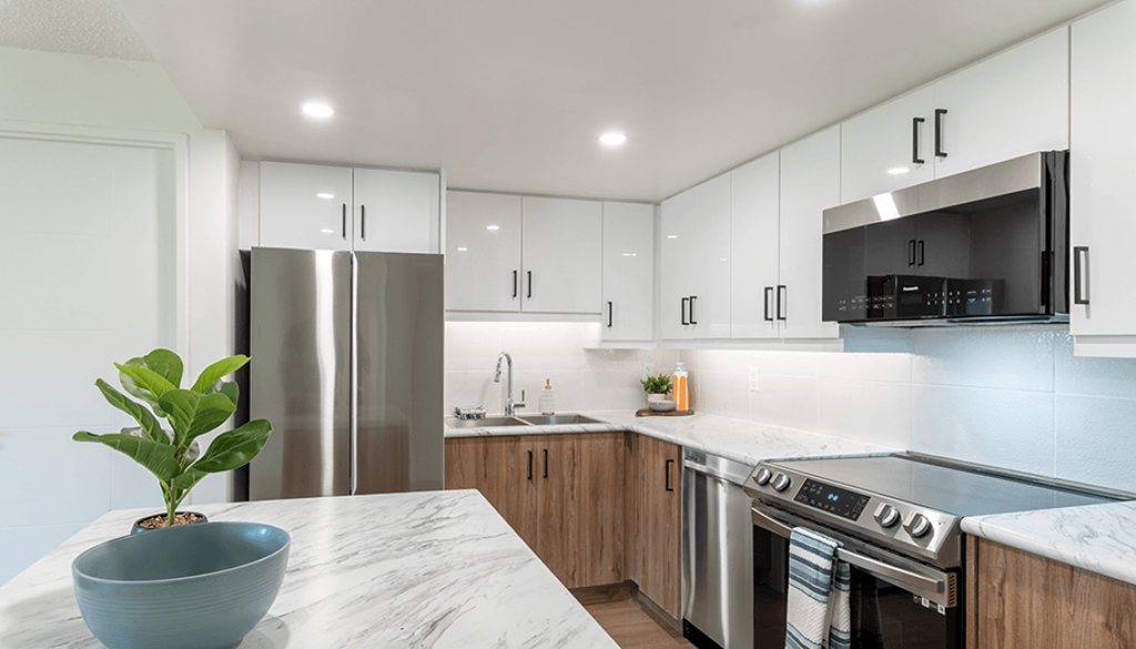 A kitchen with a marble countertop and stainless steel appliances.