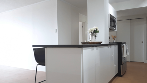 A black chair is in front of a white counter.