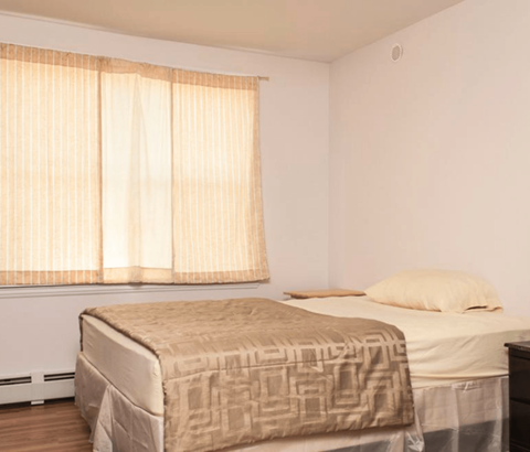 A bedroom with a bed and a window with curtains.