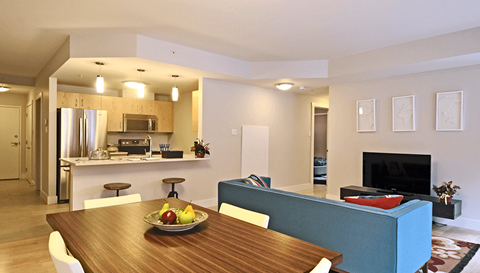 a living room and kitchen with a wooden table