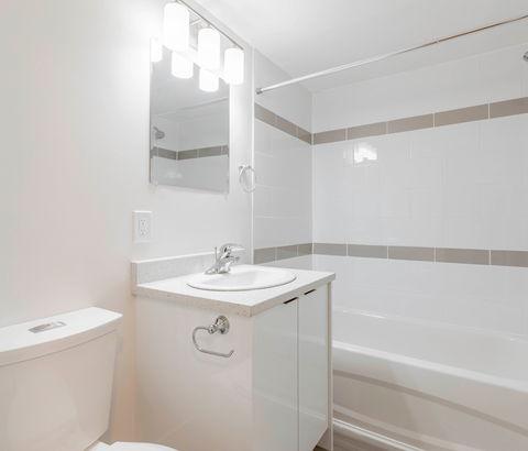 A white bathroom with a sink, toilet, and bathtub.