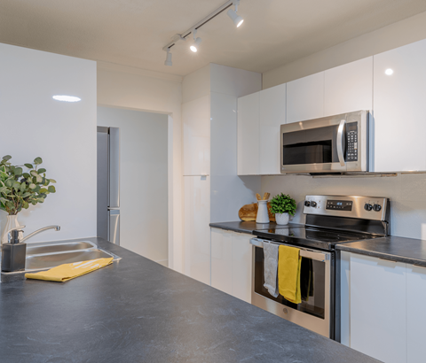A modern kitchen with a stainless steel oven and microwave.
