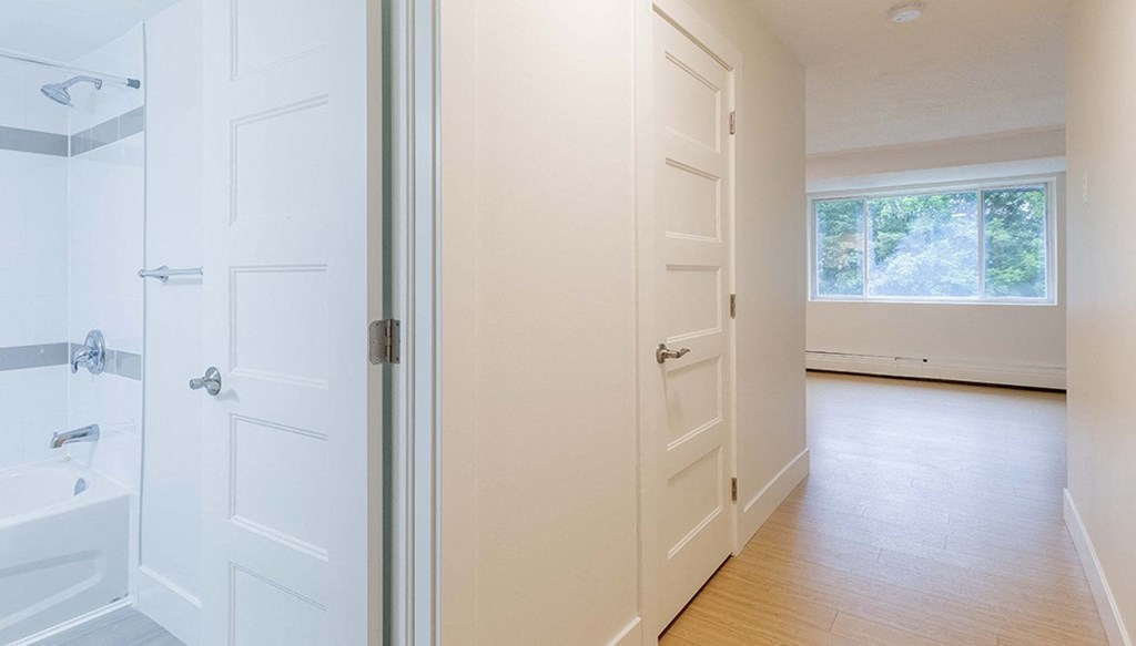 an empty bathroom with white doors and a window