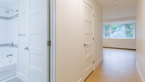an empty bathroom with white doors and a window