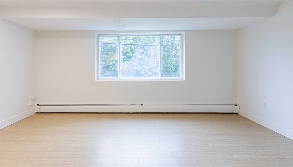 an empty room with white walls and a window