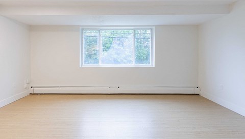 an empty room with white walls and a window