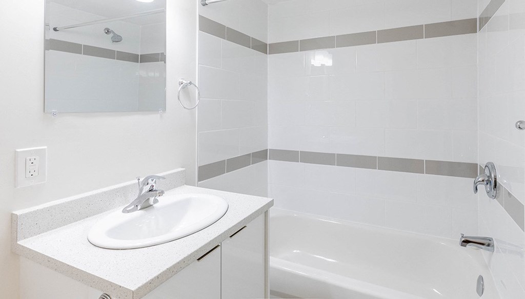 a white bathroom with a sink and a bath tub