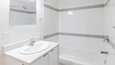 a white bathroom with a sink and a bath tub