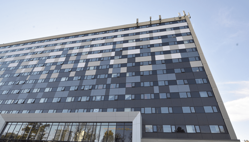 a tall office building with a blue sky in the background
