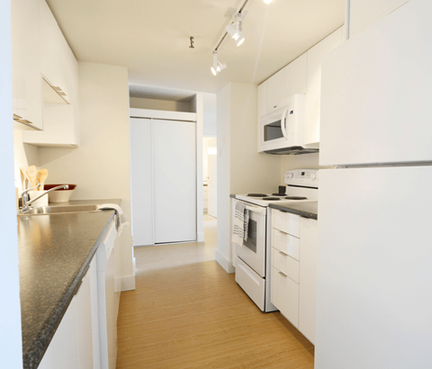 A kitchen with white cabinets and appliances.