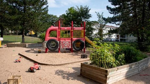 a childrens playground with a red swing set