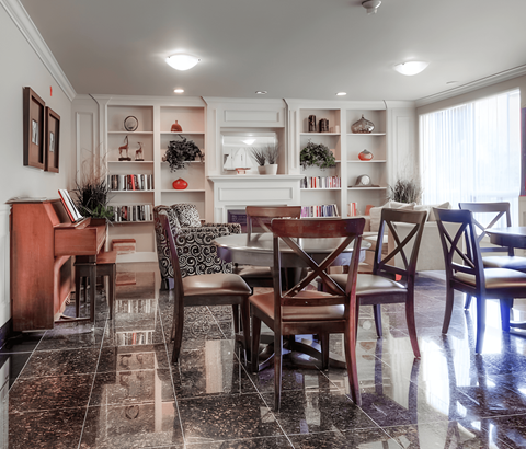 A dining room with a piano and a table set for four.