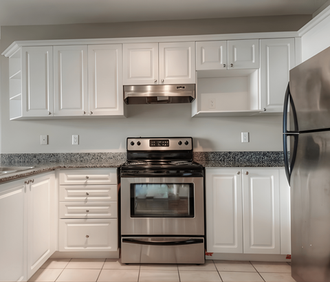 A kitchen with white cabinets and a black stove top oven.