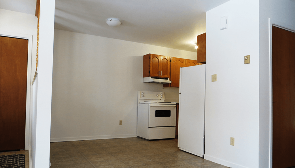 a kitchen with white appliances and wooden cabinets and a white refrigerator