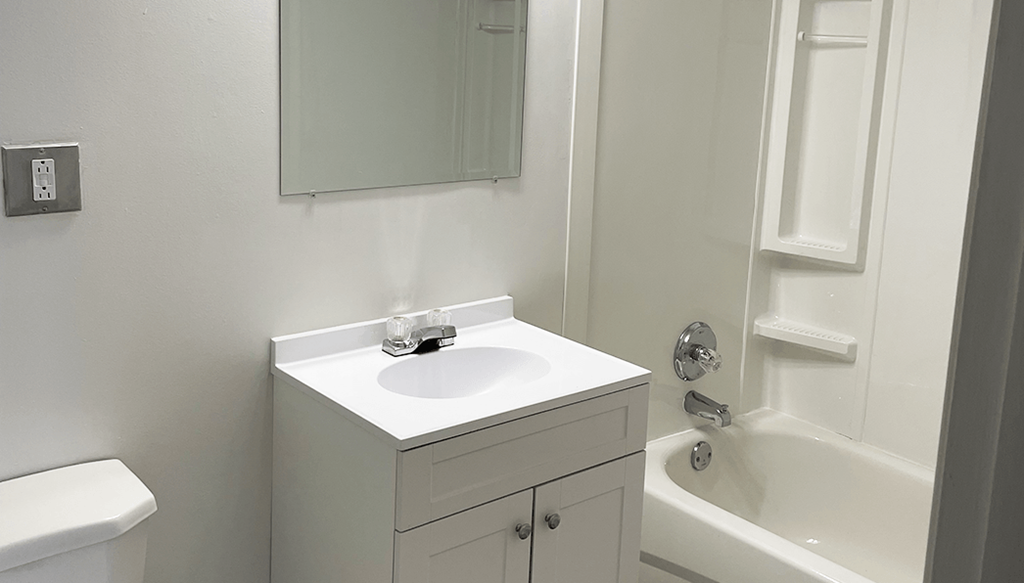 a white bathroom with a sink and a shower