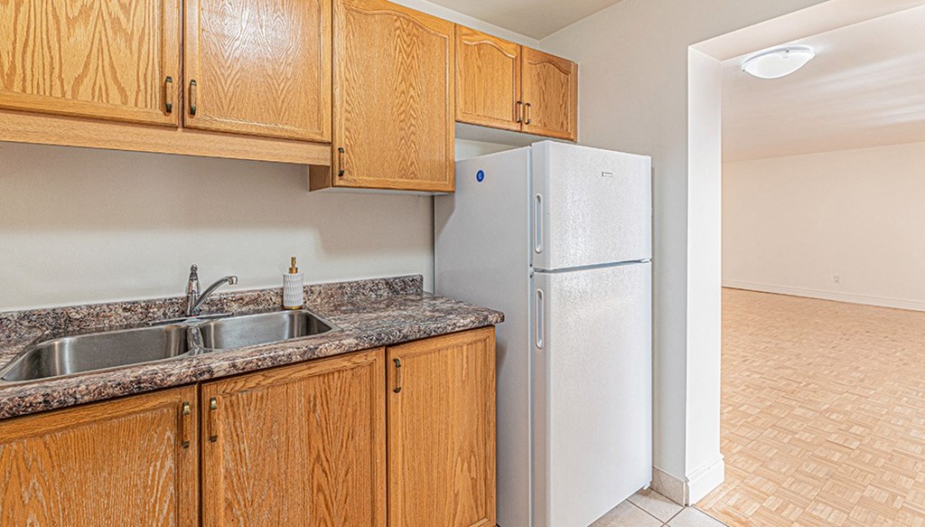 a kitchen with wooden cabinets and a white refrigerator
