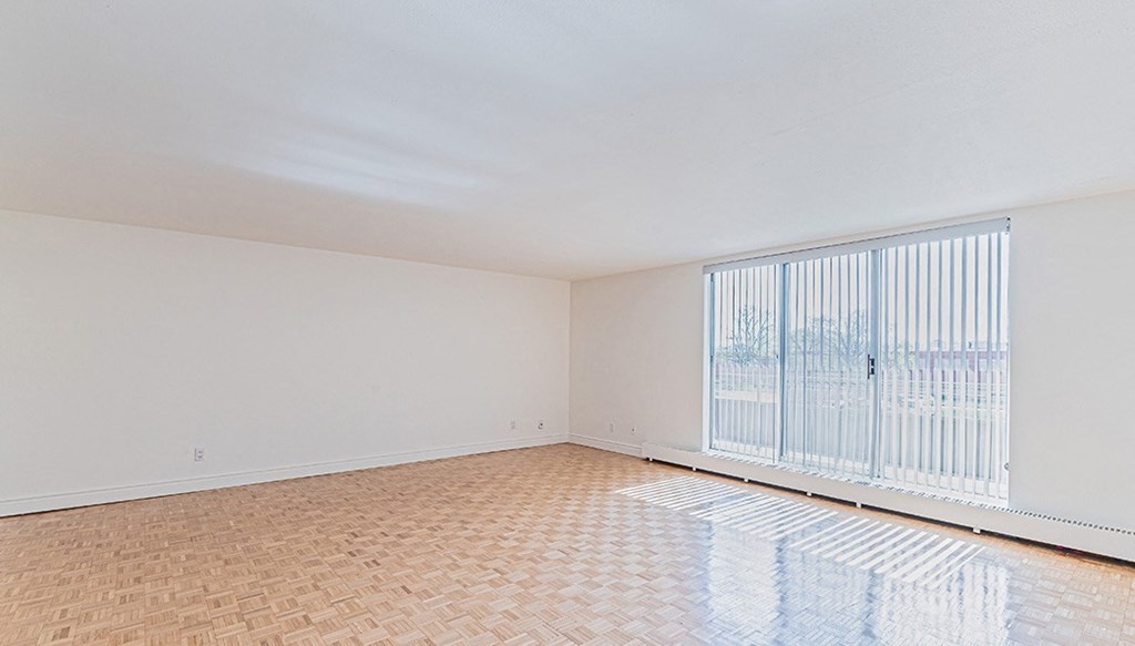 the living room of an empty apartment with a large window