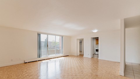 an empty living room with a large window and a tiled floor