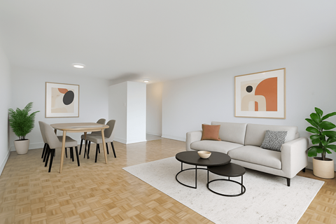 A living room with a grey couch, a black coffee table, a dining table with chairs, and two potted plants.