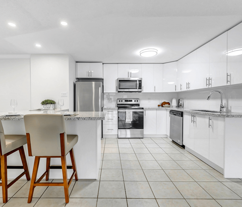 A modern kitchen with white cabinets and appliances.