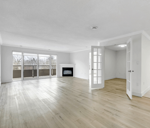 A spacious room with a fireplace and large windows.