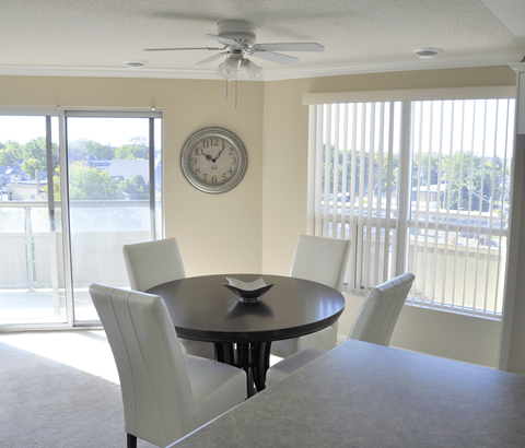 A dining room with a round table and four chairs.