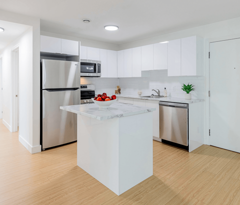 A modern kitchen with a white island in the middle.