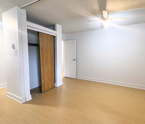 A room with a ceiling fan and a doorway leading to another room.
