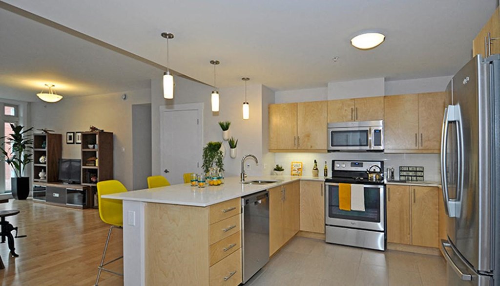 a large kitchen with wooden cabinets and stainless steel appliances