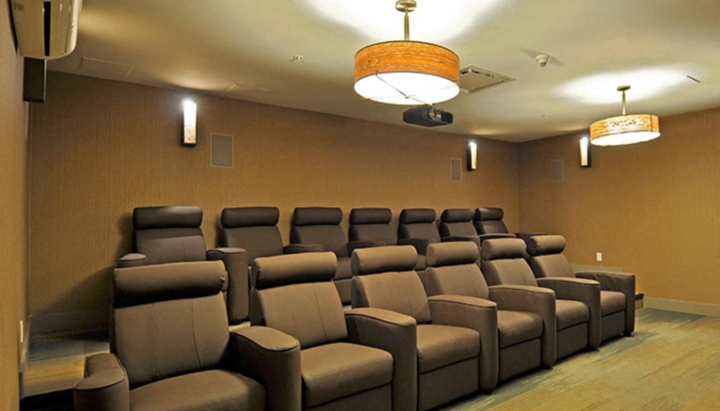 a large screening room with chairs and a projector