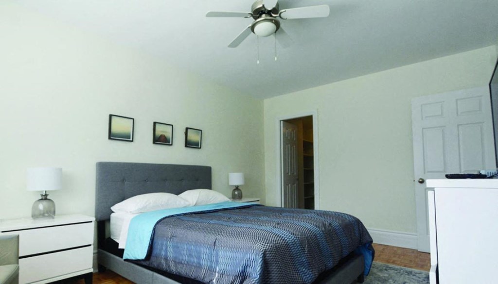 a bedroom with a bed and a ceiling fan