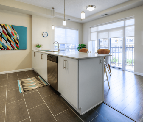 A kitchen with white cabinets and a painting on the wall.