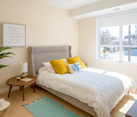 A bedroom with a large bed and a framed quote on the wall.
