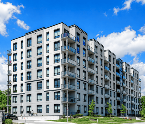 A large white apartment building with balconies and multiple windows.