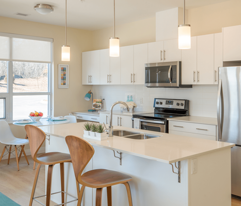 A kitchen with white cabinets and a white countertop.