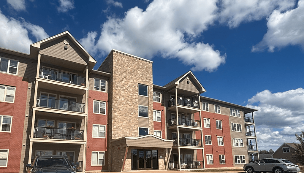 A large apartment complex with multiple balconies and a clear blue sky.